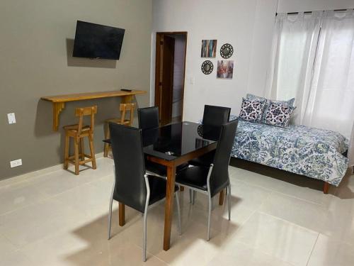a dining room with a table and chairs and a bed at ApartaHotel Los Naranjos in Apartadó