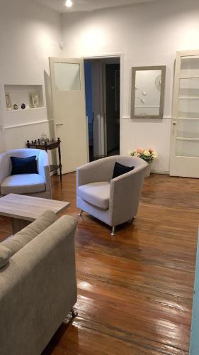 a living room with two couches and a wooden floor at Casa Lola in Mendoza
