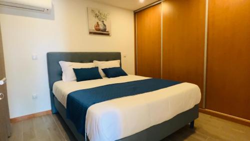 ein Schlafzimmer mit einem großen Bett mit blau-weißer Bettwäsche in der Unterkunft School Motorhome Park in Óvoa