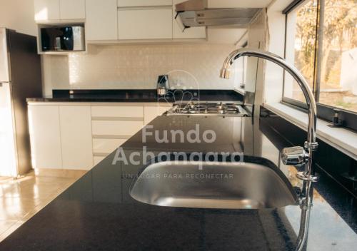 eine Küche mit einer Spüle und einem Wasserhahn in der Unterkunft Fundo Achanqara Cieneguilla in Lima