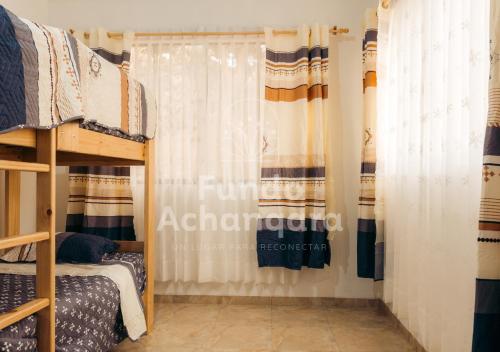 Zimmer mit Etagenbetten und einem Vorhang in der Unterkunft Fundo Achanqara Cieneguilla in Lima