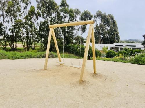 a swing set in the sand in a park at Departamento Banus Marbella piso 1 in Maitencillo