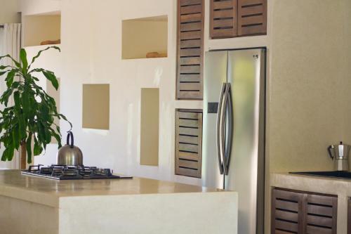 a kitchen with a refrigerator and a counter top at Afreeka Beach Hotel in Las Terrenas