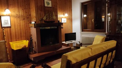een woonkamer met een open haard en een televisie bij Villetta dei tramonti in San Feliciano