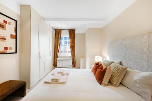 sypialnia z dużym białym łóżkiem i oknem w obiekcie Spacious and Modern 4 beds home in Kensington w Londynie