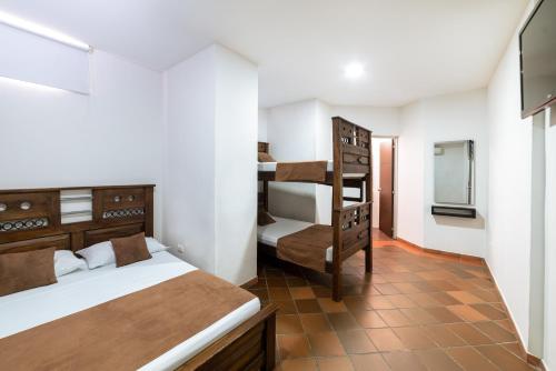 a bedroom with two beds and a bunk bed at HOTEL TASAJERO VIP in Cúcuta