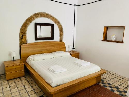 1 dormitorio con 1 cama con cabecero de madera en Porta Conca Apartments, en Rieti