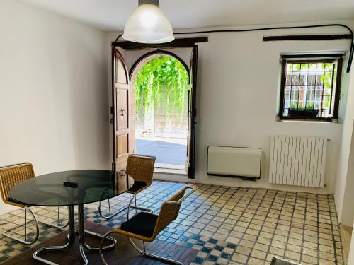 comedor con mesa de cristal y sillas en Porta Conca Apartments, en Rieti