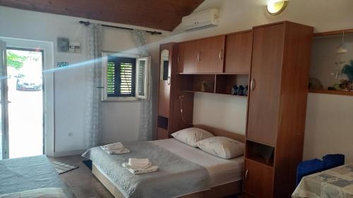 a bedroom with a bed and a cabinet with towels on it at Apartments by the sea Postira, Brac - 9241 in Postira