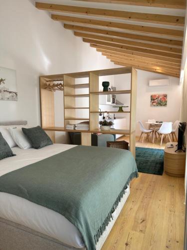 a bedroom with a large bed and a dining room at Horta dos Cedros in Tomar