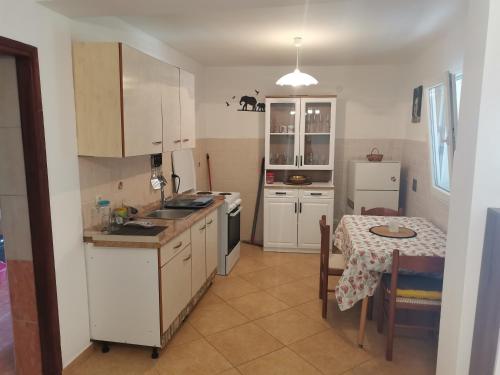cocina con armarios blancos, mesa y comedor en Apartments with a parking space Metajna, Pag - 4127, en Zubovići