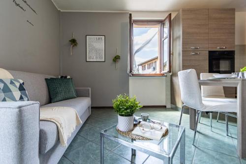 a living room with a couch and a table at SMART FLAT - Lago Maggiore - Private Garage, Wi-Fi in Castelletto sopra Ticino