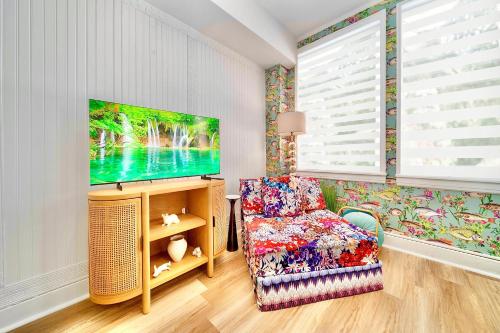 a living room with a tv and a chair at King Bed Mermaid suite - heart of Palm Beach, free parking included in Palm Beach