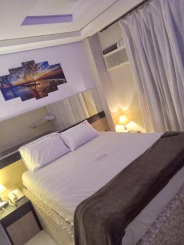 une chambre avec un grand lit dans une pièce dans l'établissement Hotel Las Vegas Guarulhos, à Guarulhos