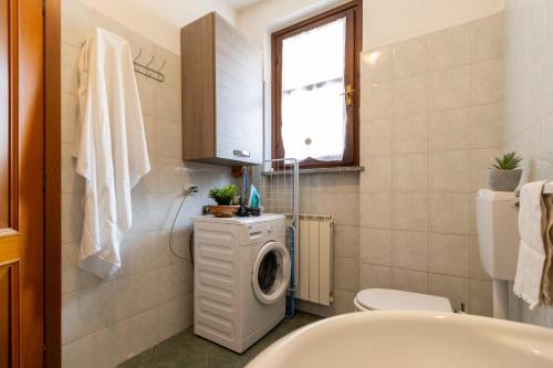 y baño con lavadora y lavamanos. en [SMART FLAT] Private Garage, Wi-Fi, Netflix en Castelletto sopra Ticino