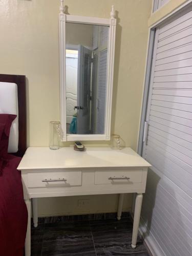 lavabo blanco con espejo en Digna alojamientos, en Juan Pedro