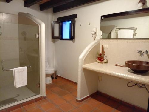 y baño con lavabo y ducha. en Hotel Boutique Casabella, en Coatepec