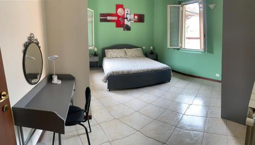 1 dormitorio con cama, escritorio y espejo en Garibaldi 26 en Stresa