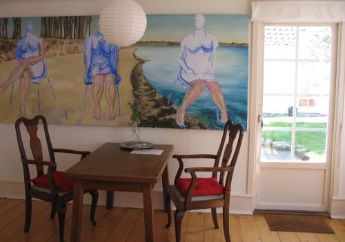 a dining room with a table and chairs and a painting at Thurø Kro B&B in Svendborg