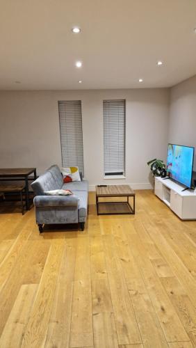 a living room with a couch and a table at London City Apartment in Ealing