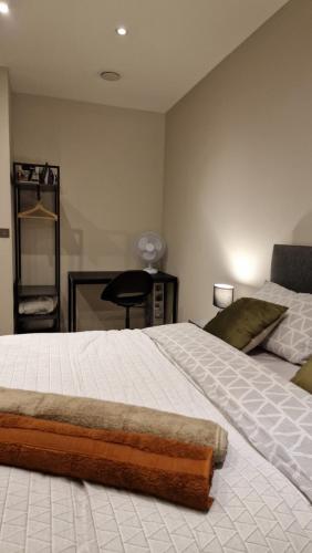 a bedroom with a large bed and a desk at London City Apartment in Ealing