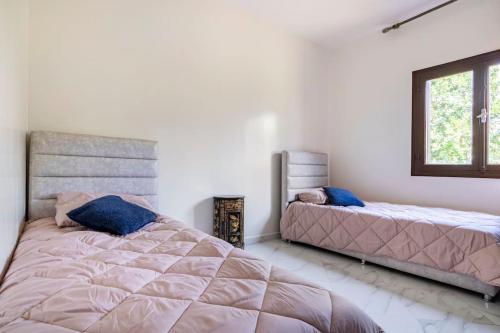 um quarto com 2 camas e uma janela em Appartement chaleureux et calme, Parking, Jardin em Agadir