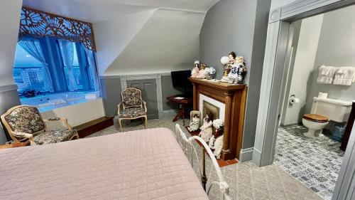 a bedroom with a bed and a desk and a fireplace at The Hancock House Bed & Breakfast Inn in Dubuque