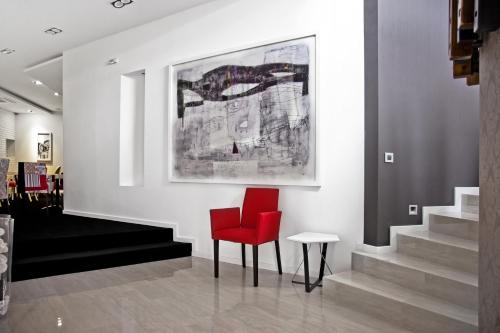 a red chair in a room with stairs at Garni Hotel Eter in Niš