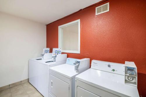 una stanza con tre lavatrici e una parete arancione di Rodeo Inn a Pecos
