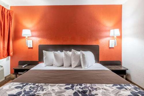 Posto letto in camera d'albergo con parete arancione di Rodeo Inn a Pecos