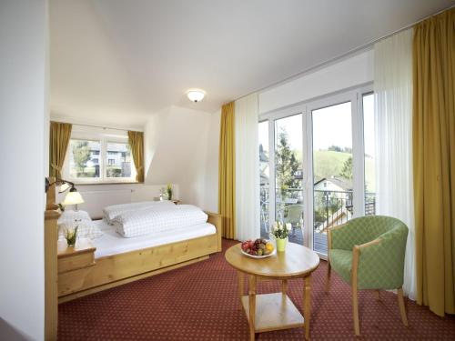 a bedroom with a bed and a table and window at Gasthof Restaurant Bürgerstüble in Sankt Peter