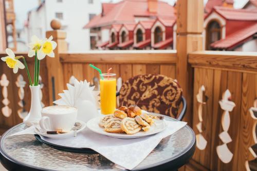 a table with a plate of pastries and a cup of coffee at Svityaz Resort in Truskavets