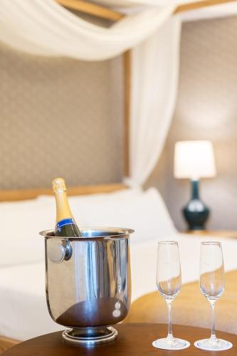 a bottle of champagne in a bucket on a table with two glasses at Parador de Ciudad Rodrigo in Ciudad-Rodrigo