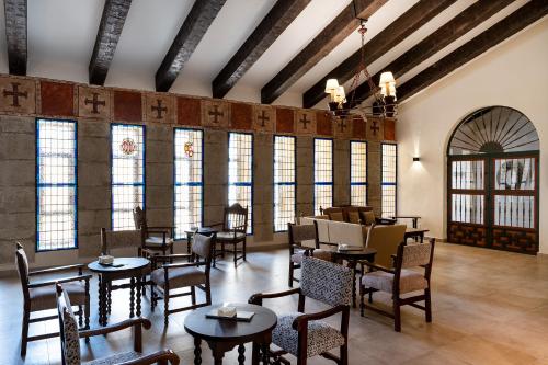 Un restaurante con mesas, sillas y ventanas. en Parador de Ciudad Rodrigo, en Ciudad Rodrigo