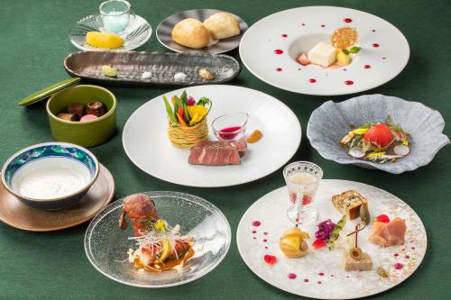 a group of plates of food on a green table at Matsumoto Hotel Kagetsu in Matsumoto
