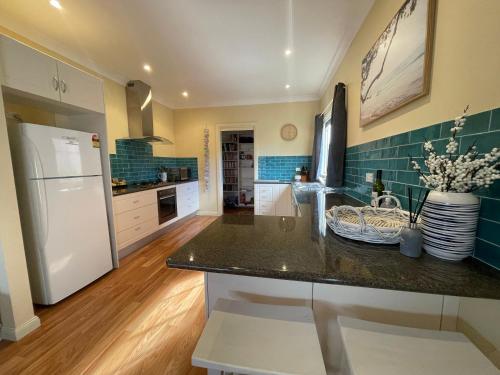 a kitchen with a counter and a refrigerator at Award winning - Open plan Coastal Beauty in Patonga Beach - Pet Friendly in Patonga