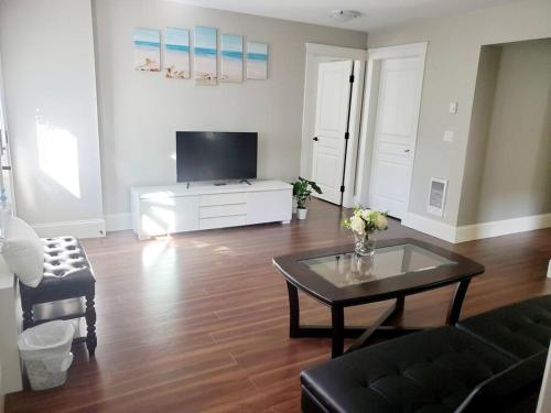 een woonkamer met een salontafel en een televisie bij BlueBack BeachFront 2-Bedroom Private Apartment in Nanaimo