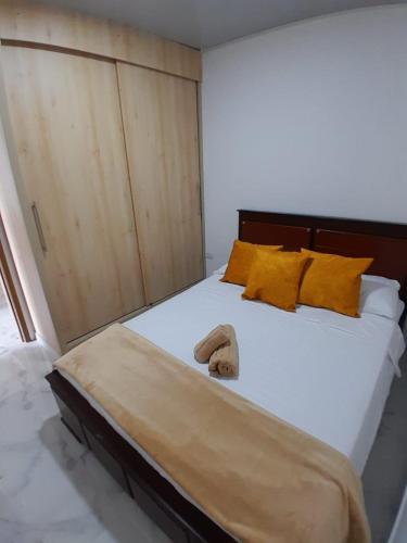 a bedroom with a large bed with yellow pillows at Apartamento Amoblado en la via Termales Santa Rosa de Cabal in Santa Rosa de Cabal