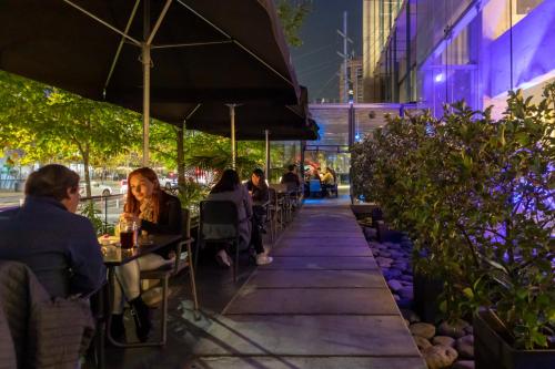 people sitting at tables outside a restaurant at night at Best Western Premier Marina Las Condes in Santiago