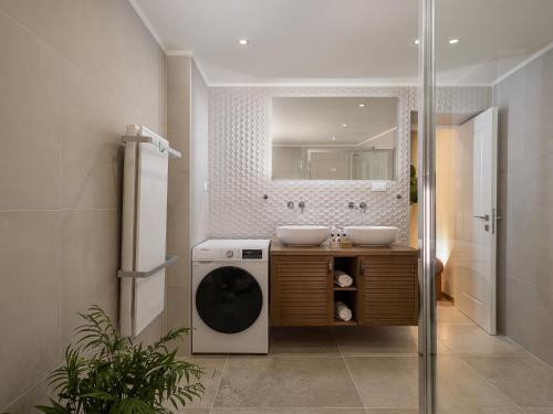 a bathroom with a washing machine and a sink at Theros Home in Chania