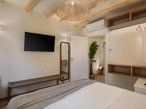 a bedroom with a bed and a flat screen tv on the wall at Theros Home in Chania