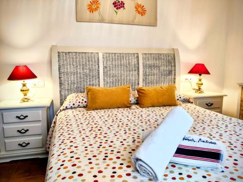 een slaapkamer met een bed met 2 nachtkastjes en 2 lampen bij Apartamento Rural Villa Aurora in Luque