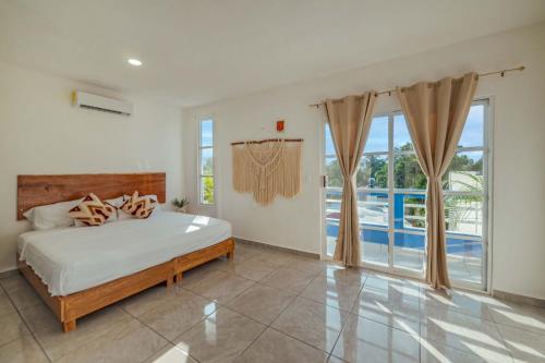a bedroom with a bed and a view of a pool at Suites Ha in Isla Mujeres