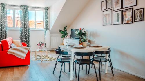 een woonkamer met een tafel en stoelen en een rode bank bij Prague Retreat Apartment in Praag