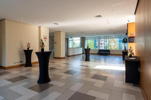 a lobby with black vases with flowers in it at Best Western Premier Marina Las Condes in Santiago