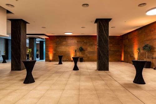 a lobby with columns and tables in a building at Best Western Premier Marina Las Condes in Santiago