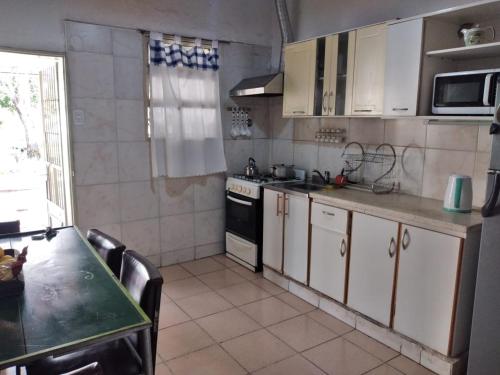 a kitchen with white cabinets and a stove top oven at Mama Maruja in San Luis