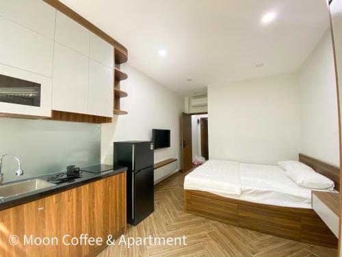 a bedroom with a bed and a kitchen with a sink at Moon Apartment in Ho Chi Minh City
