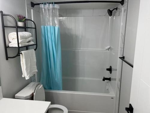 a bathroom with a shower and a white toilet at 2-bedroom basement apartment in Calgary