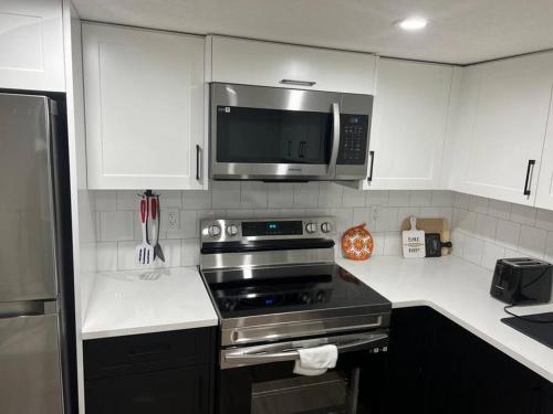 a kitchen with a stove and a microwave at 2-bedroom basement apartment in Calgary